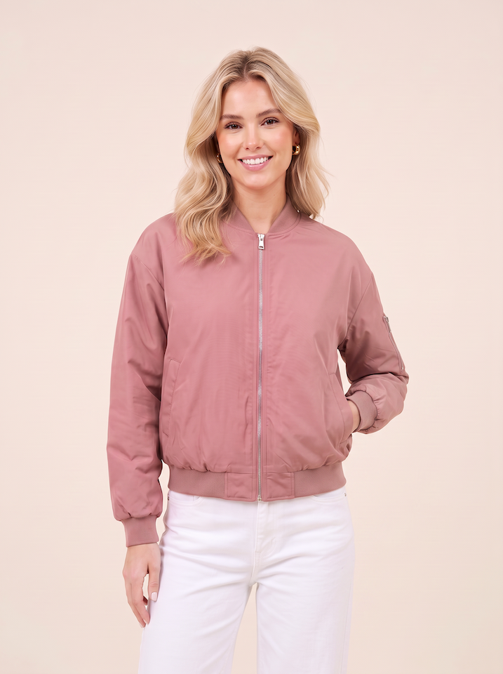 Halbtotale vom KI generiertem Modell in einem hellen Studio in einer Bomberjacke in der Farbe Altrosa vom Hamburger Modelabel Stegmann Mode