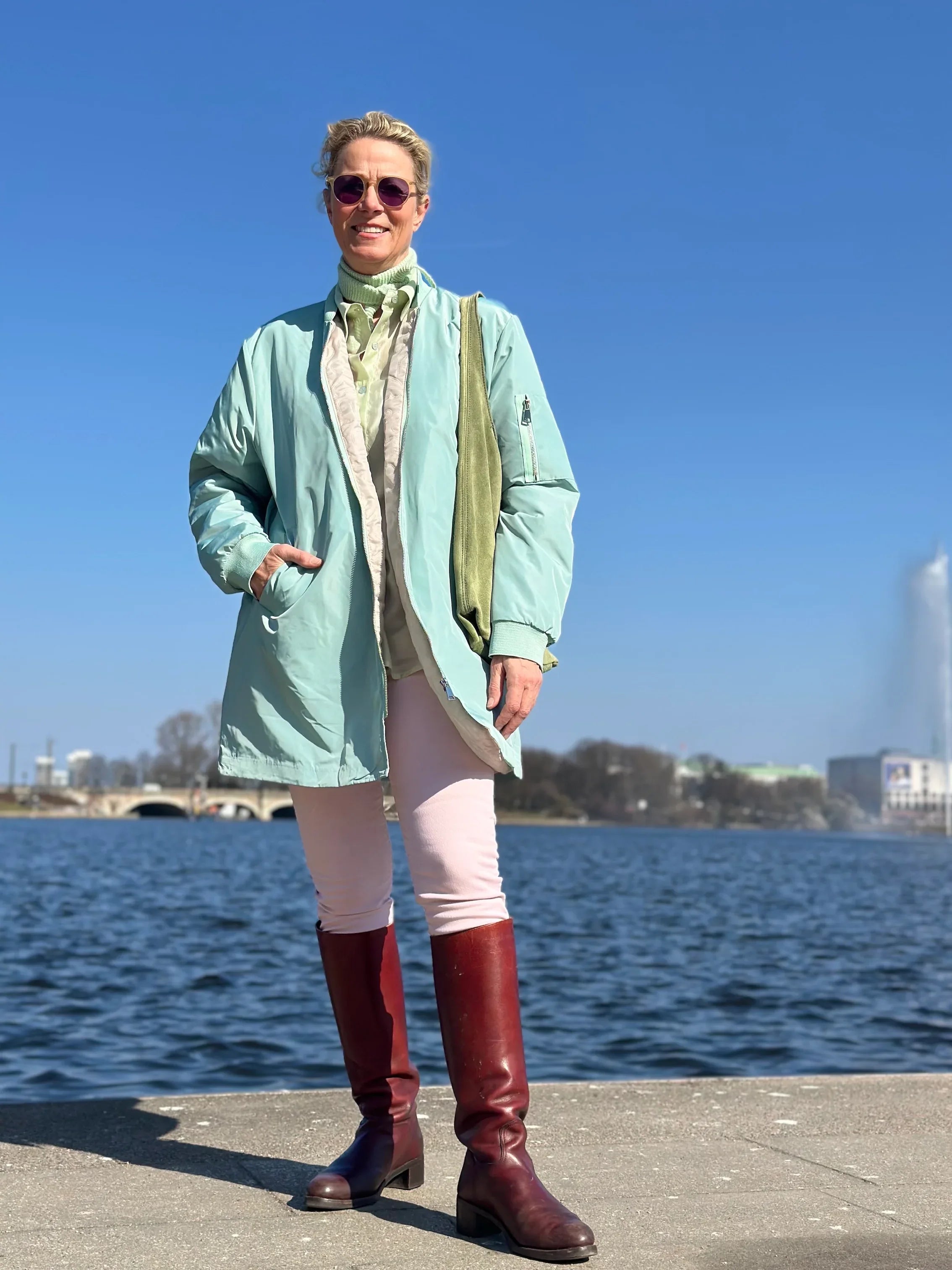 Frau vor Alster im Kurzmantel Bomber in der Farbe Mint vom Hamburger Modelabel stegmann mode