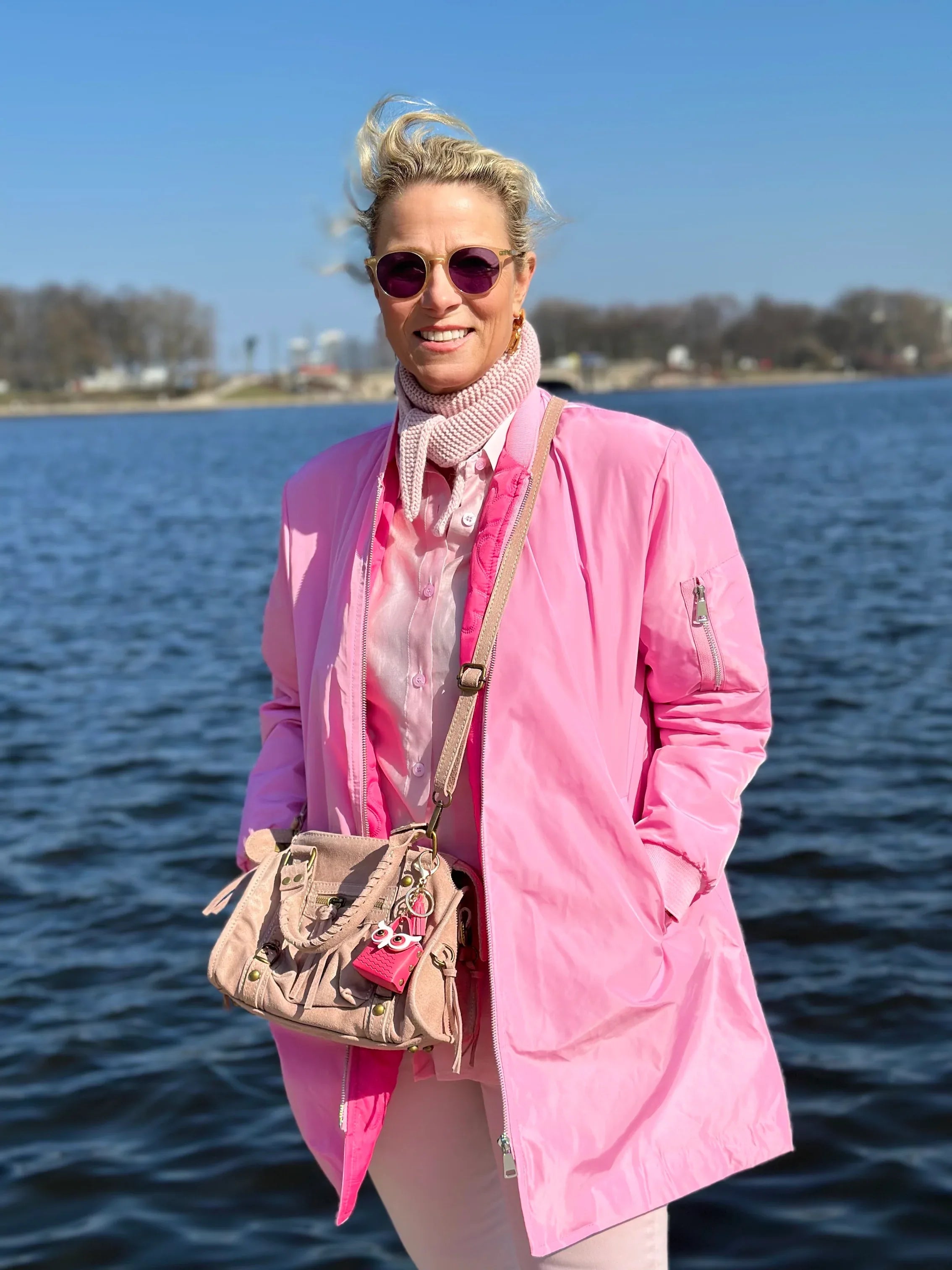 Frau vor Alster im Kurzmantel Bomber in der Farbe Pink vom Hamburger Modelabel stegmann mode