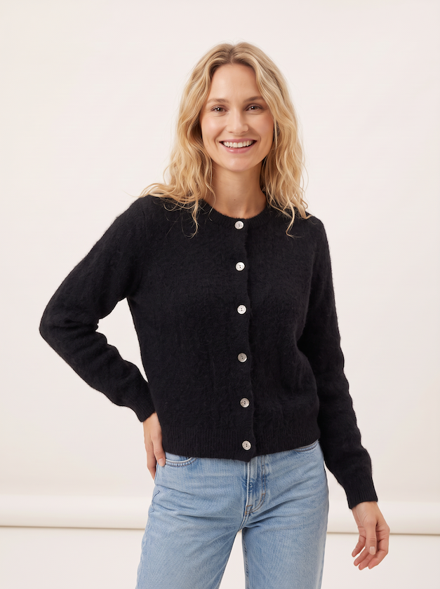 KI generiertes Modell im hellen Studio in der Strickjacke Christine in der Farbe Schwarz vom Hamburger Modelabel Stegmann Mode