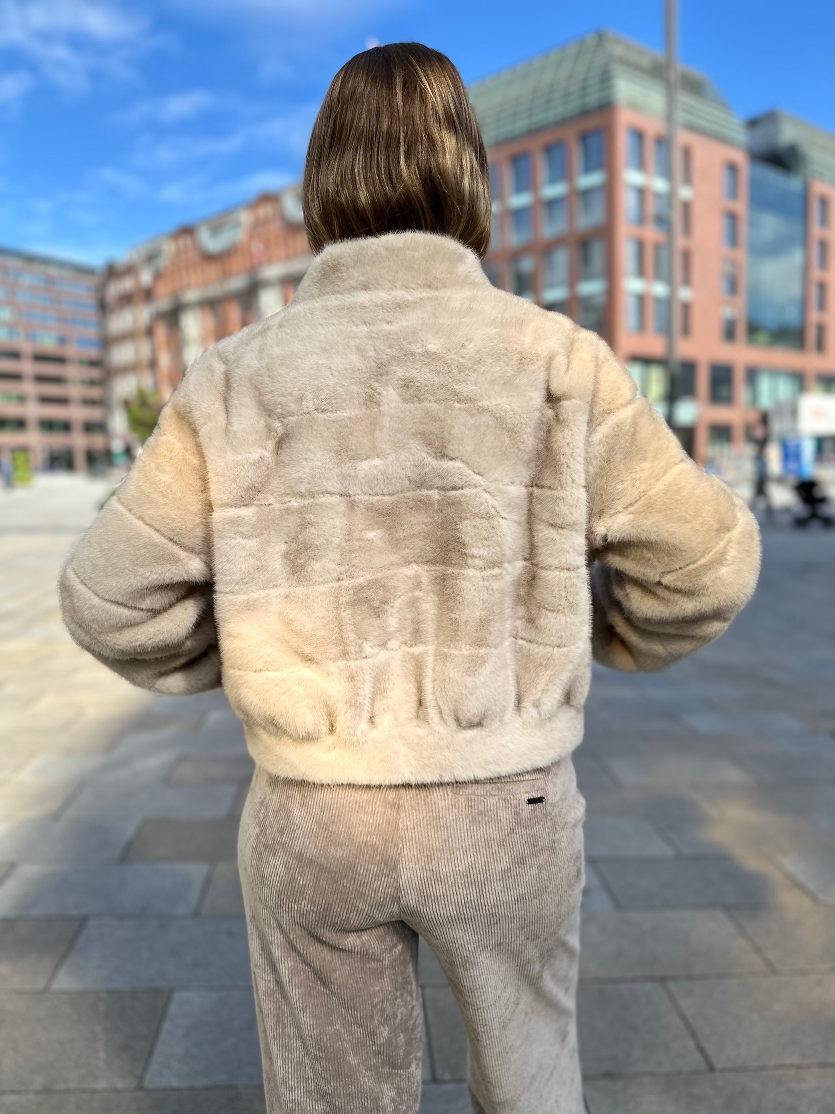 Rückansicht von kurzer Funfur Jacke in Creme im Jacky O. Style vom Hamburger Modelabel stegmann mode