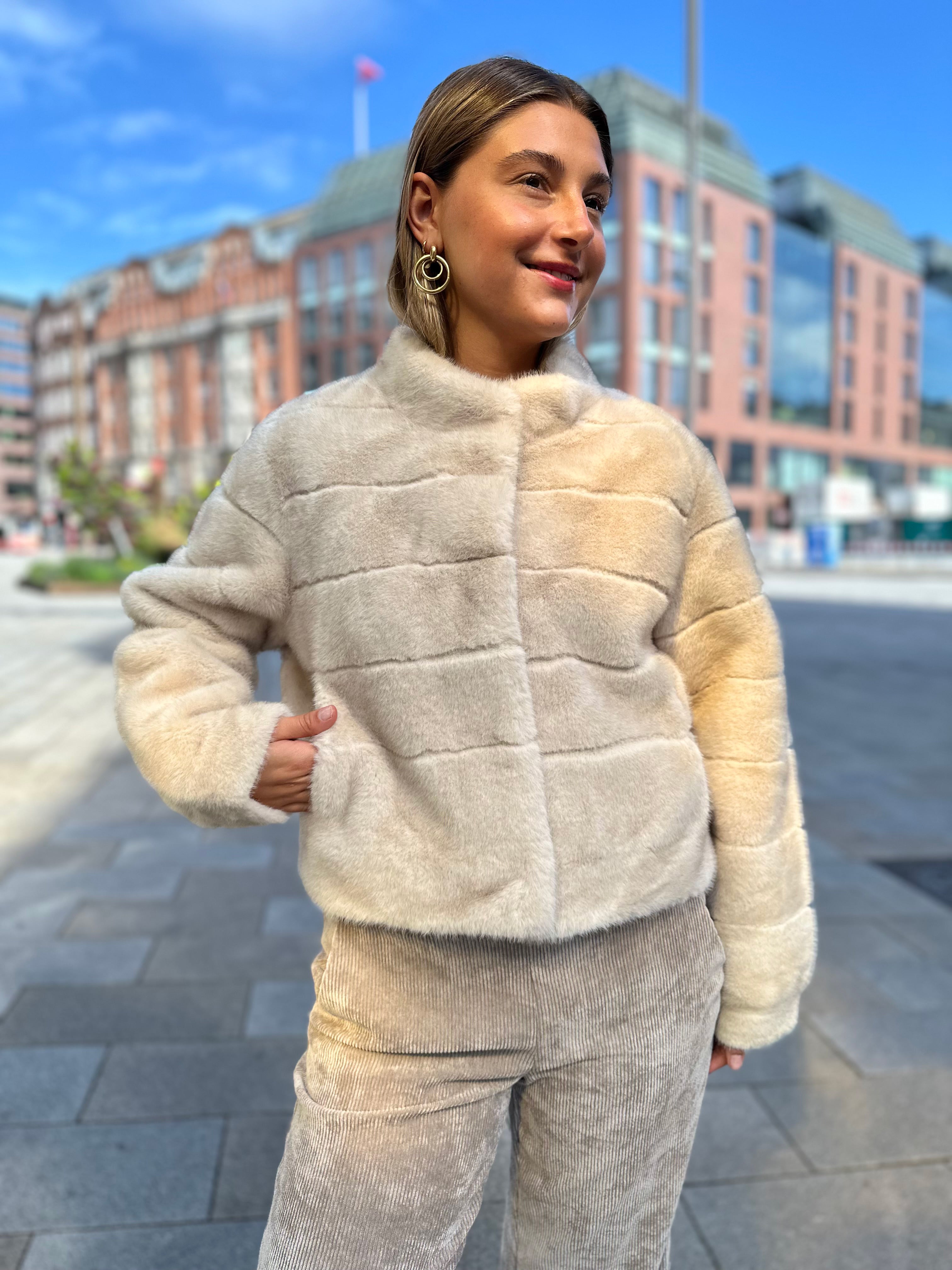 Junge Frau trägt kurze Funfur Jacke in Creme im Jacky O. Style vom Hamburger Modelabel stegmann mode