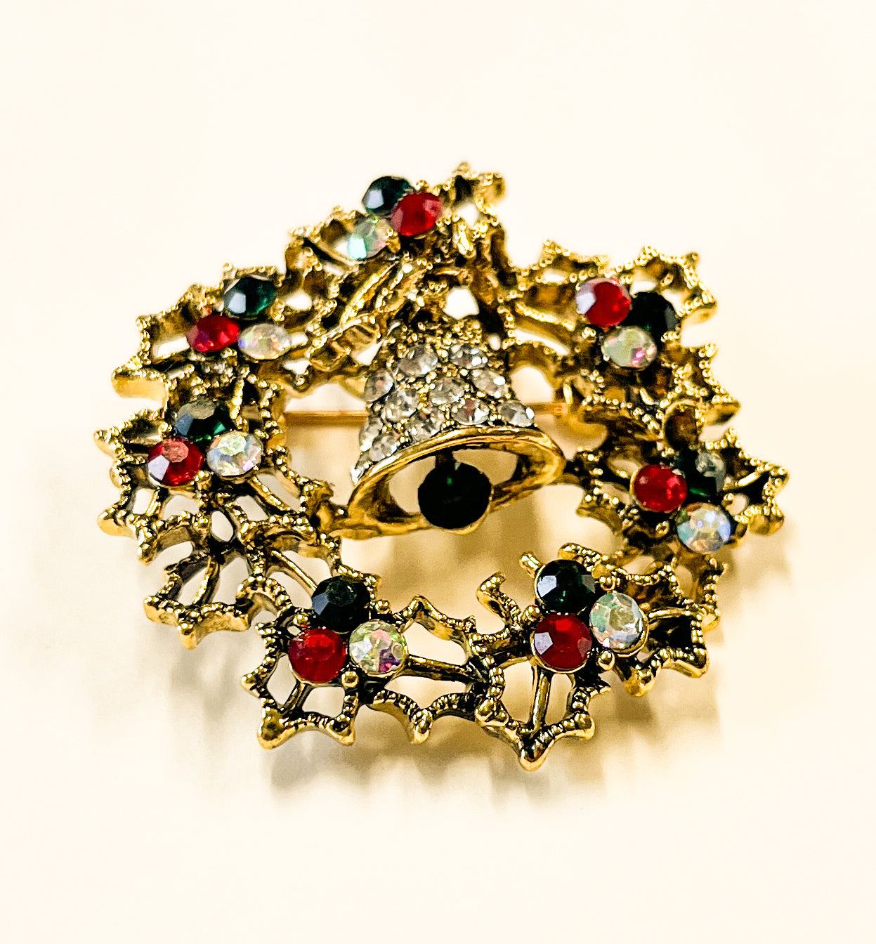 Produktfoto von weihnachtlicher Brosche in Kranzform mit Glocke in Gold vom Hamburger Modelabel stegmann mode