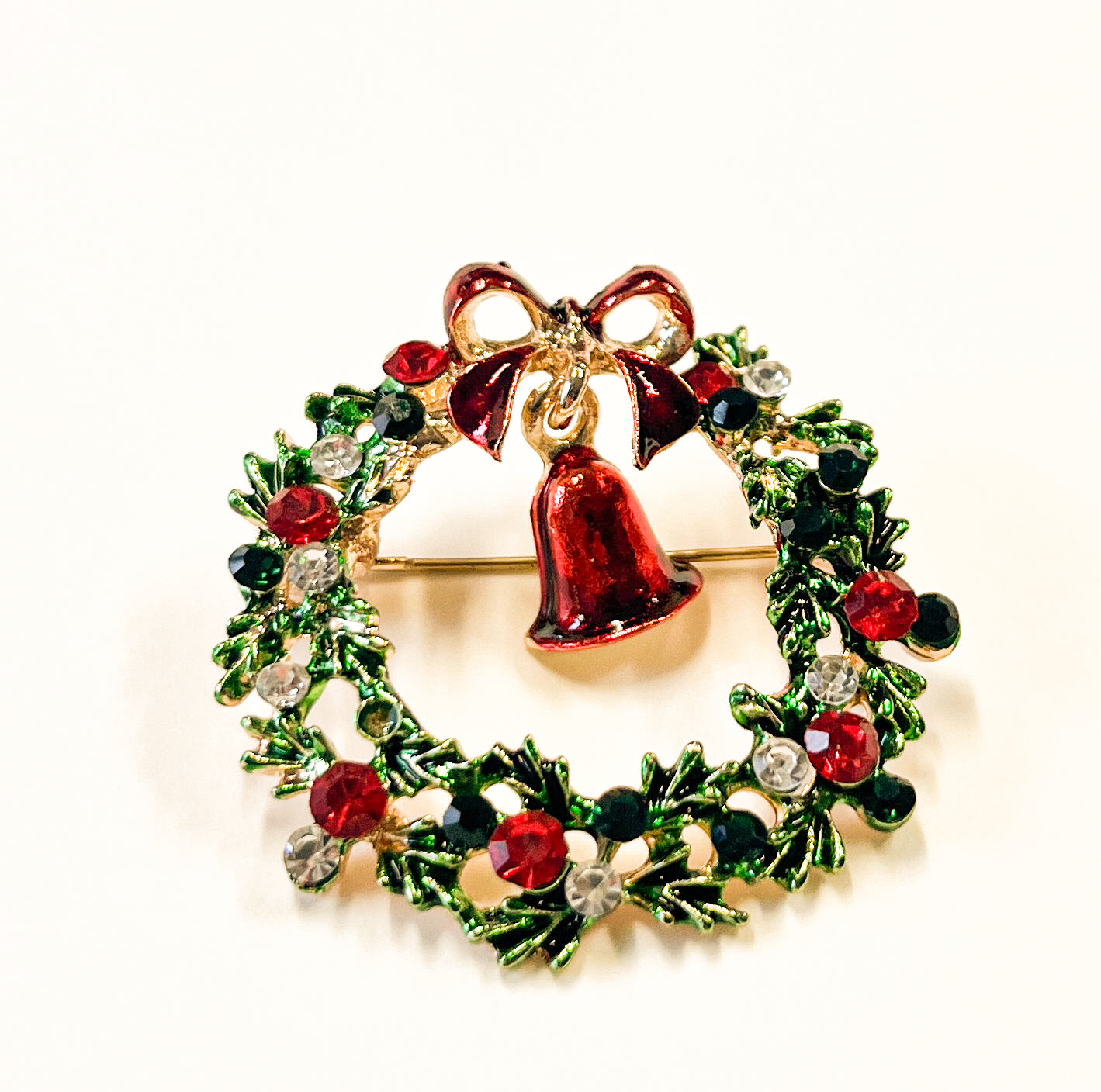 Produktfoto von weihnachtlicher Brosche in Kranzform mit Glocke in Grün vom Hamburger Modelabel stegmann mode