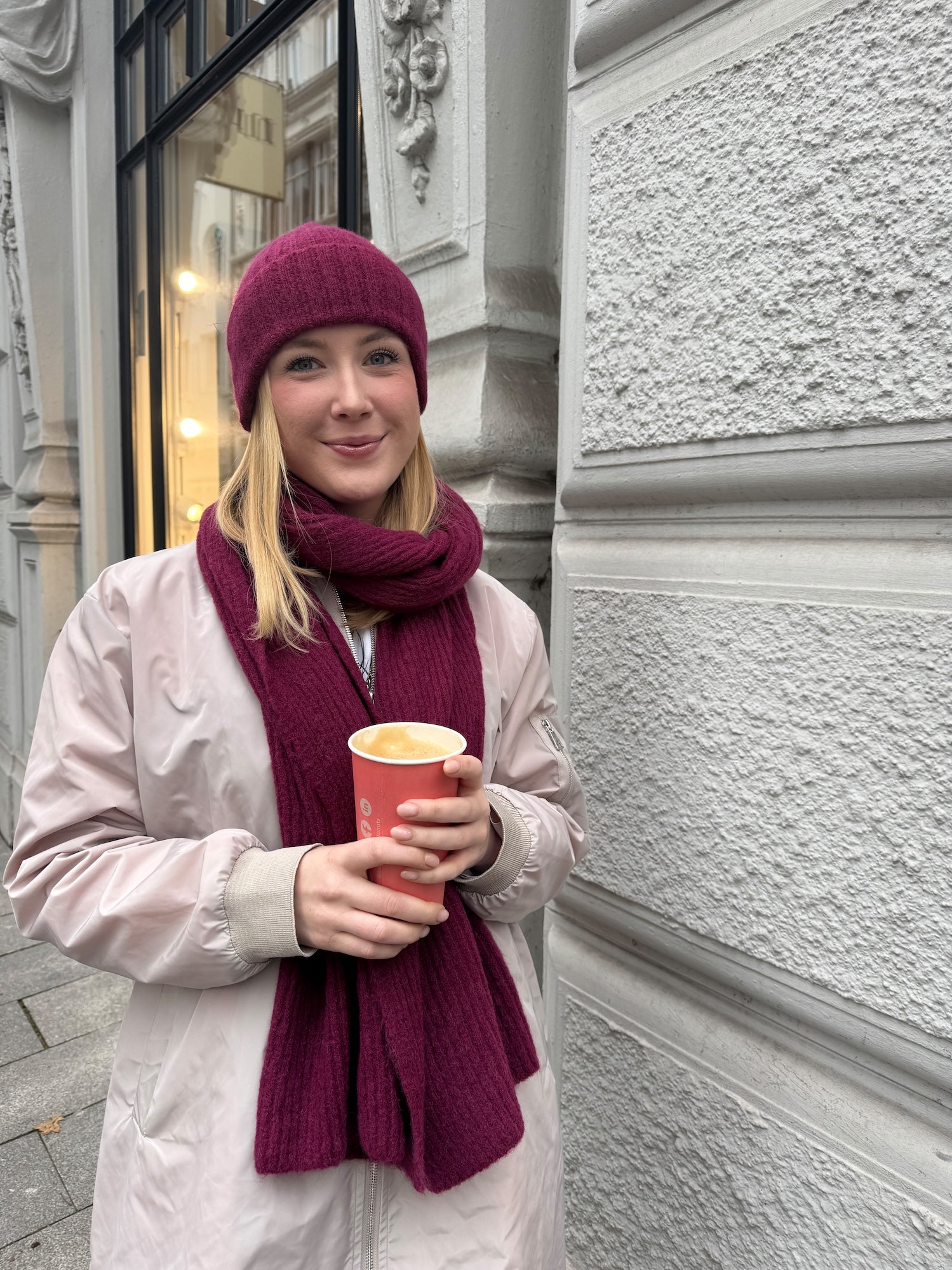 Junge Frau trägt Schal-Mützen-Set in der Farbe Burgundy vom Hamburger Modelabel stegmann moe