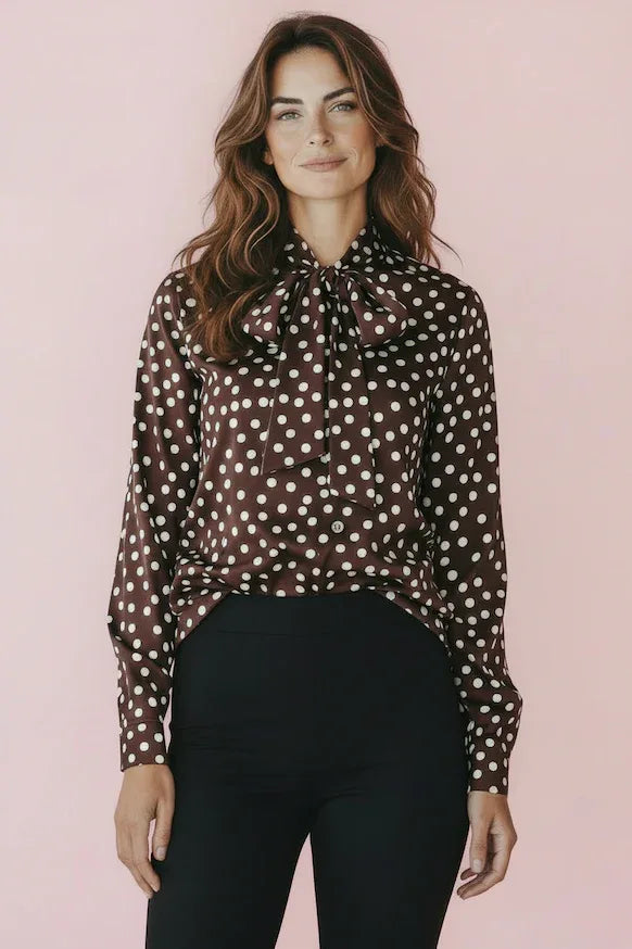 KI generiertes Modell im Studio in Bluse mit Polkadots und Schluppe in braun mit Punkten vom Hamburger Modelabel stegmann mode