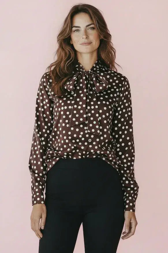 KI generiertes Modell im Studio in Bluse mit Polkadots und Schluppe in braun mit Punkten vom Hamburger Modelabel stegmann mode