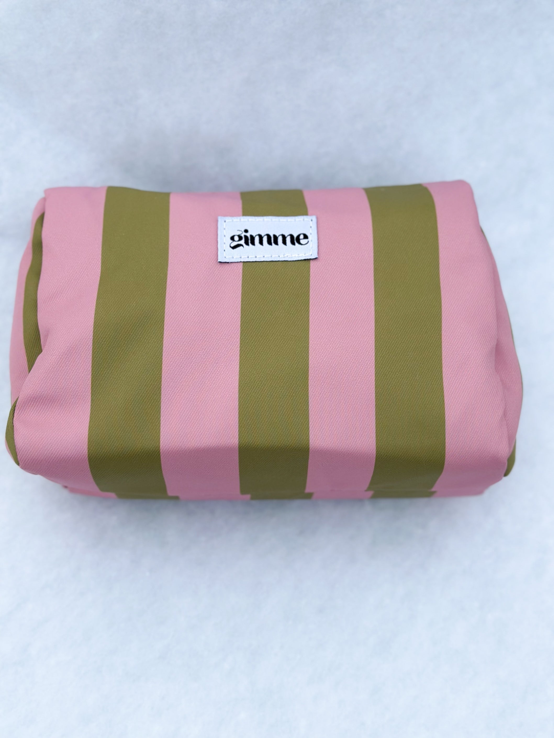 liegendes Produktfoto von Kosmetiktasche in oliv / rosa gestreift vom Hamburger Modelabel stegmann mode