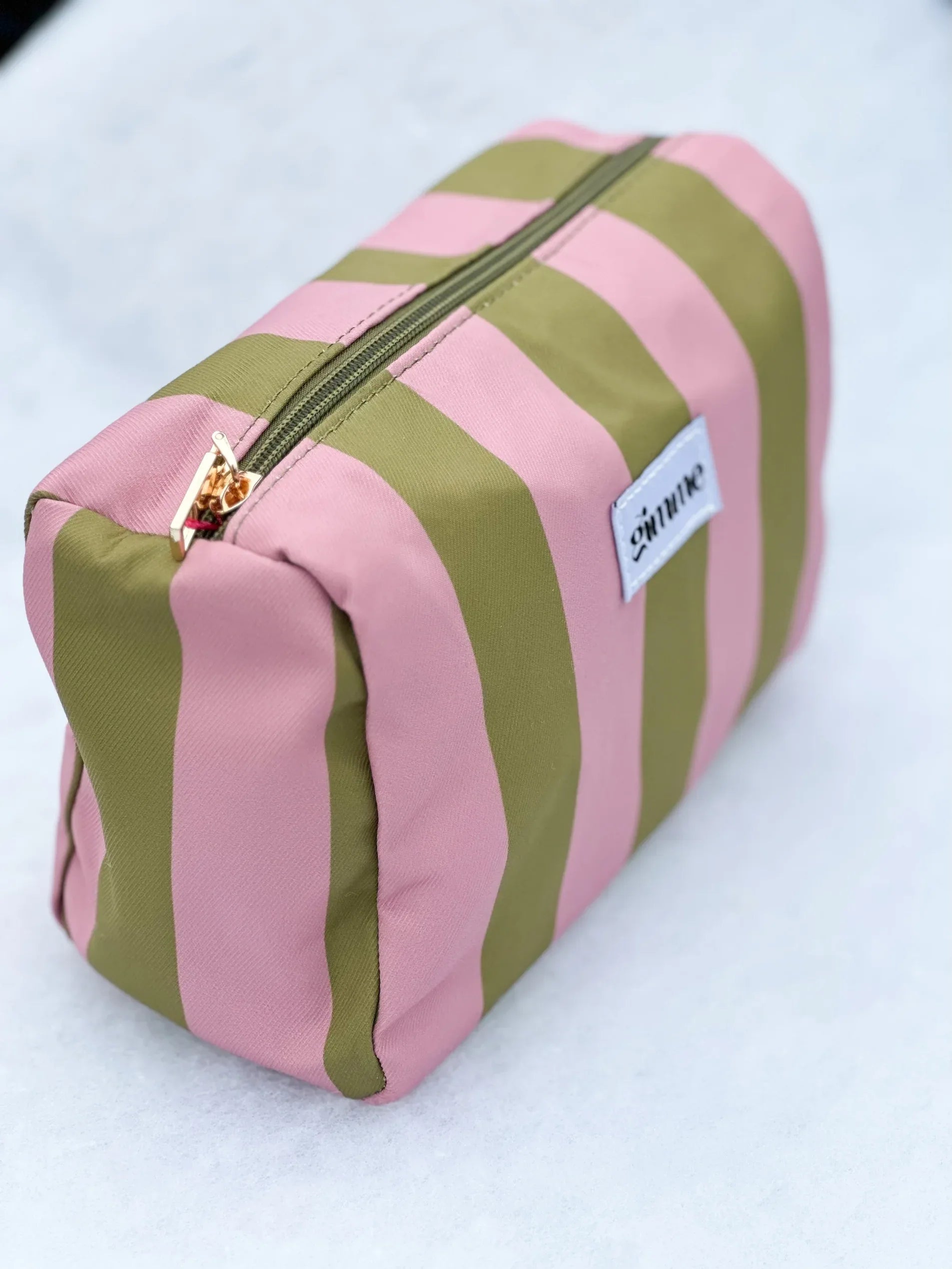 Seitliches Produktfoto von Kosmetiktasche in oliv / rosa gestreift vom Hamburger Modelabel stegmann mode