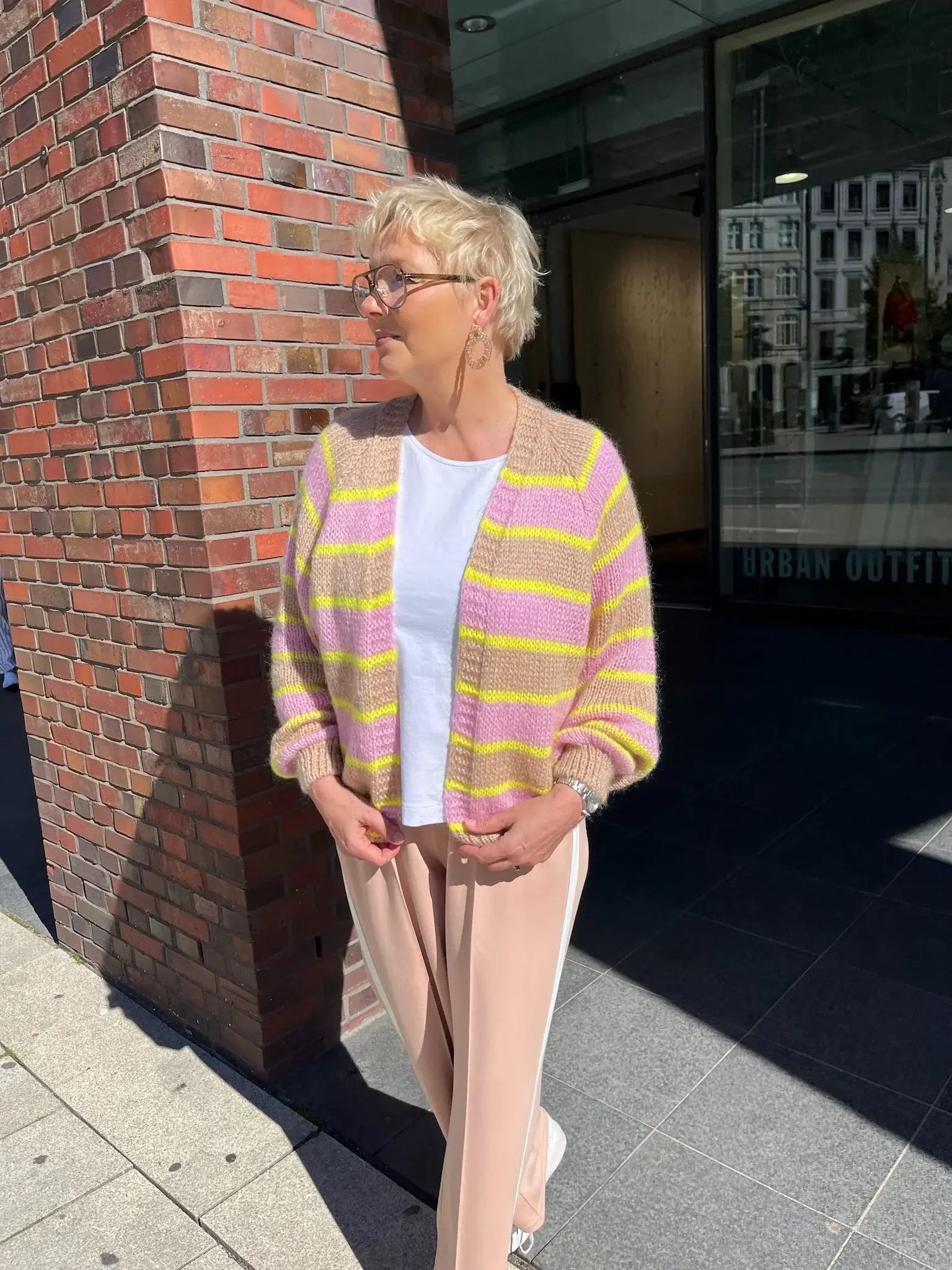 Verena trägt die gestreifte Strickjacke Marcella in den Farben Camel/Rosa/Gelb vom Hamburger Modelabel stegmann mode