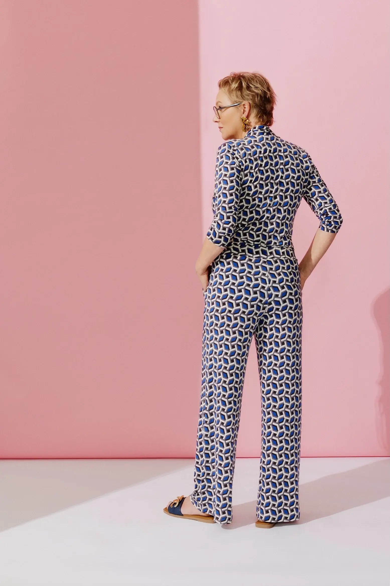 Rückansicht von Frau im Studio im Jumpsuit Carmen Combi im Print Coins Bleu vom Hamburger Modelabel stegmann mode
