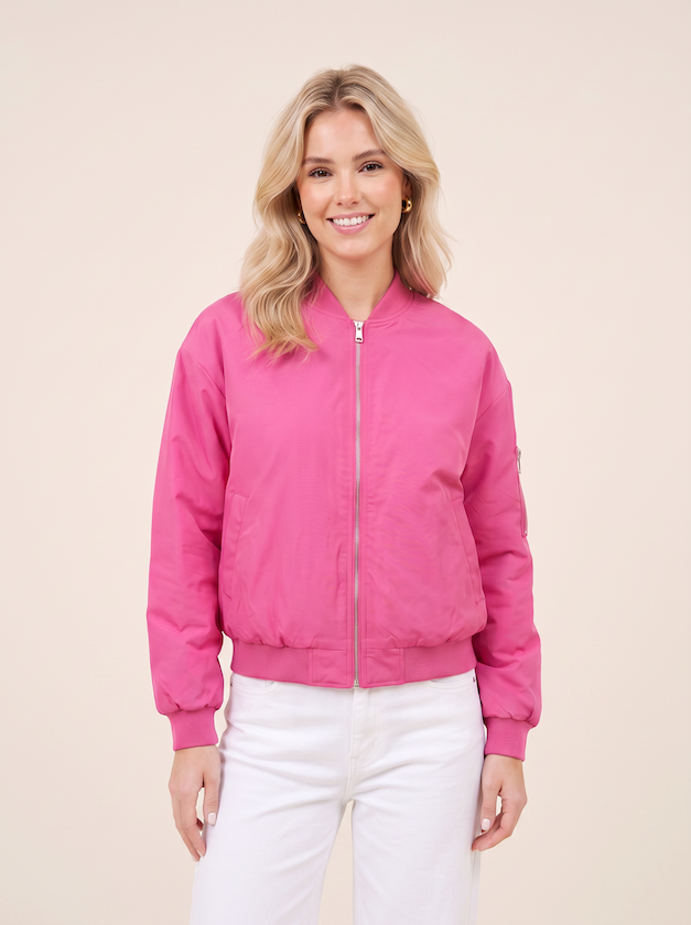 Halbtotale vom KI generiertem Modell in einem hellen Studio in einer Bomberjacke in der Farbe Pink vom Hamburger Modelabel Stegmann Mode