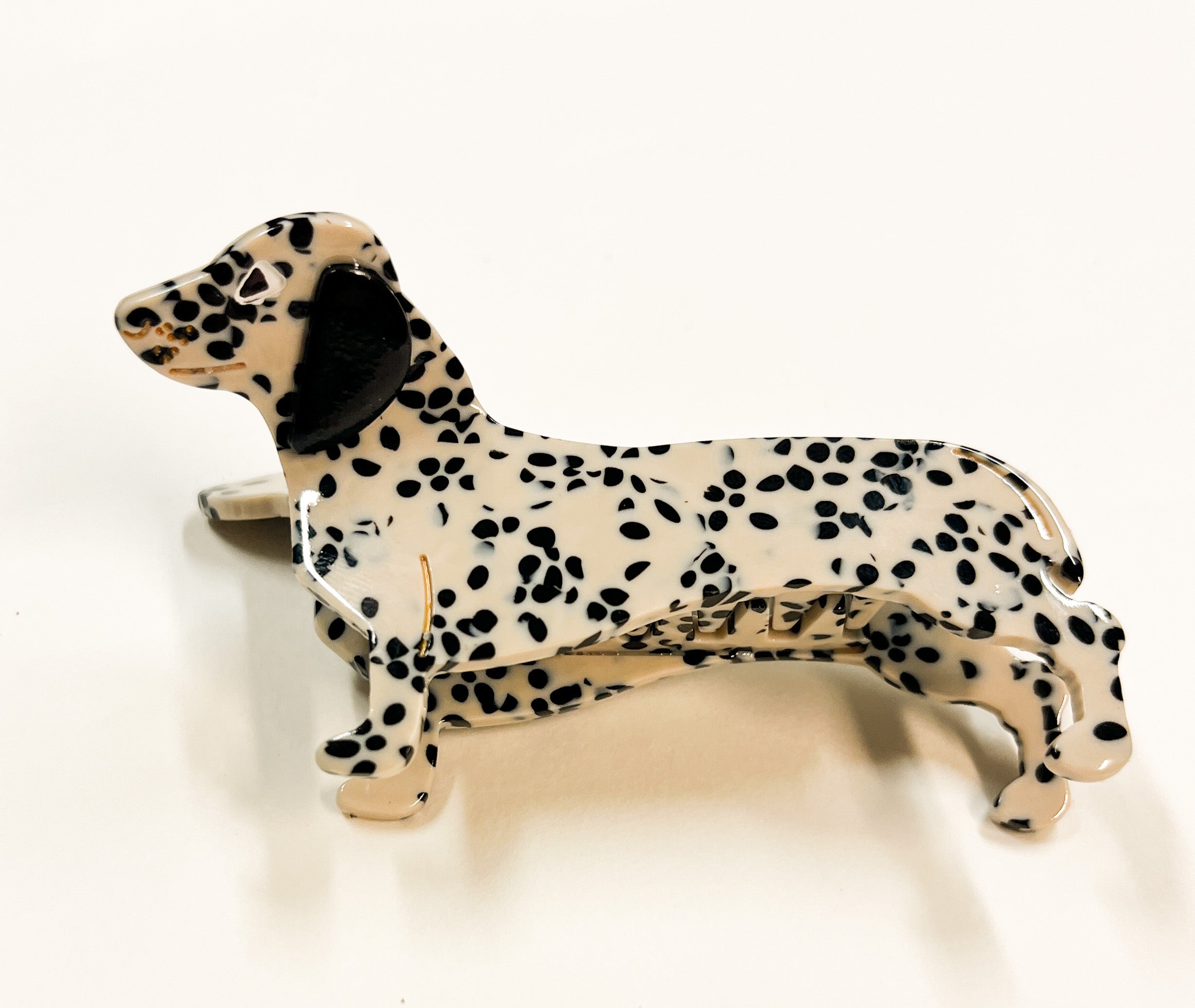 Produktfoto von Haarklammer in Dackelform in der Farbe Weiß mit schwarzen Punkten vom Hamburger Modelabel stegmann mode