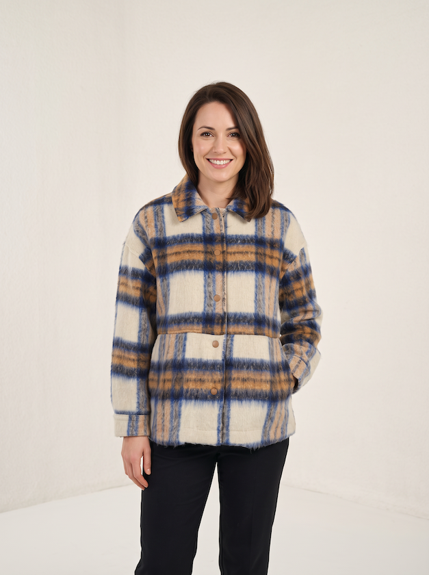 KI generiertes Modell im hellen Studio in der karierten Lumberjacke vom Hamburger Modelabel Stegmann Mode