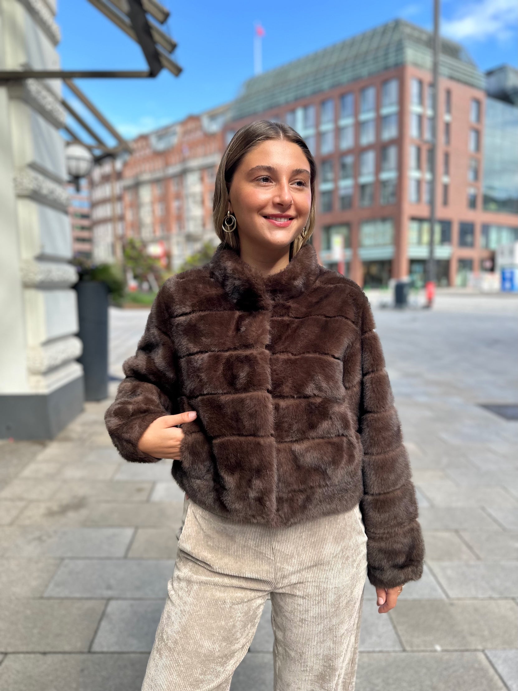 Junge Frau trägt kurze Funfur Jacke in Braun im Jacky O. Style vom Hamburger Modelabel stegmann mode