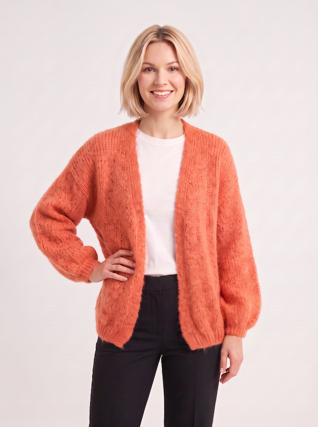 KI generiertes Modell in einem hellen Studio in der Strickjacke Lilli in der Farbe orange vom Hamburger Modelabel Stegmann Mode