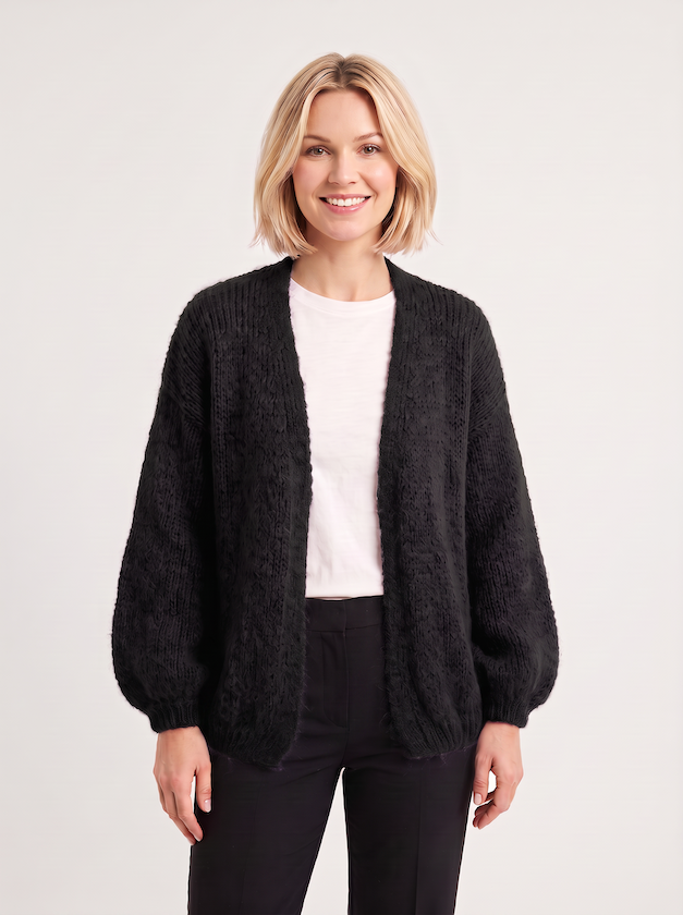 KI generiertes Modell in einem hellen Studio in der Strickjacke Lilli in der Farbe schwarz vom Hamburger Modelabel Stegmann Mode