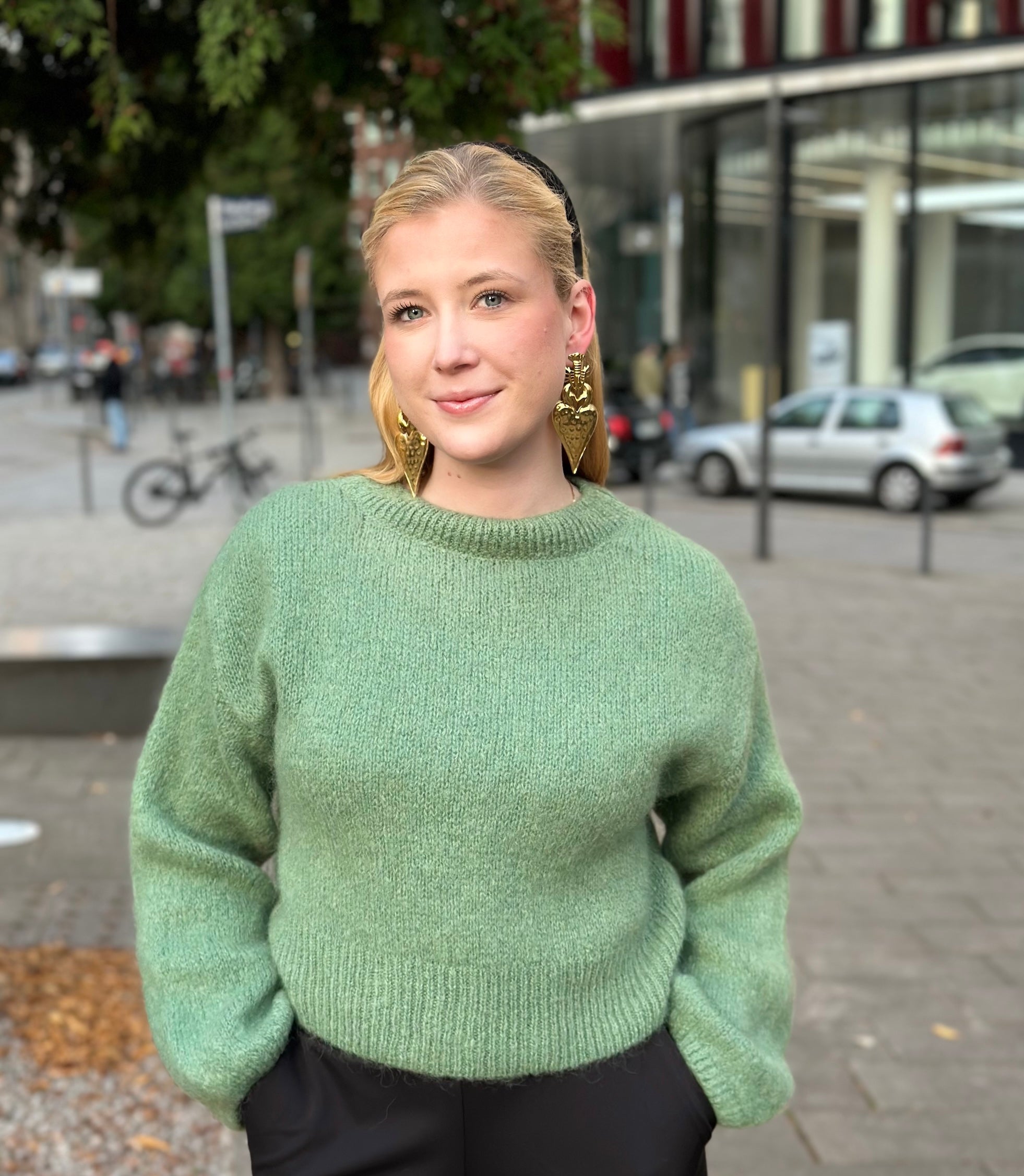 Junge Frau im kurzen Pullover Maja in der Farbe Salbei vom Hamburger Modelabel stegmann mode