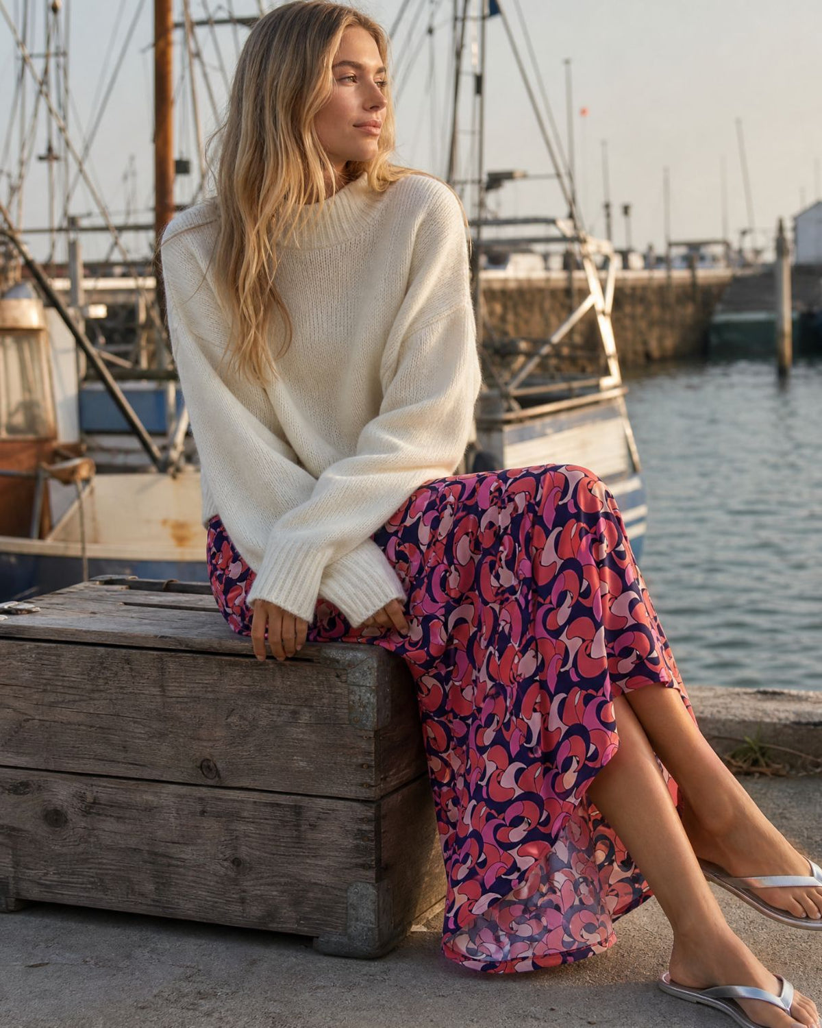 KI generiertes Model sitzend am Hafen im Rock Marleen im Print Yves vom Hamburger Modelabel Stegmann Mode