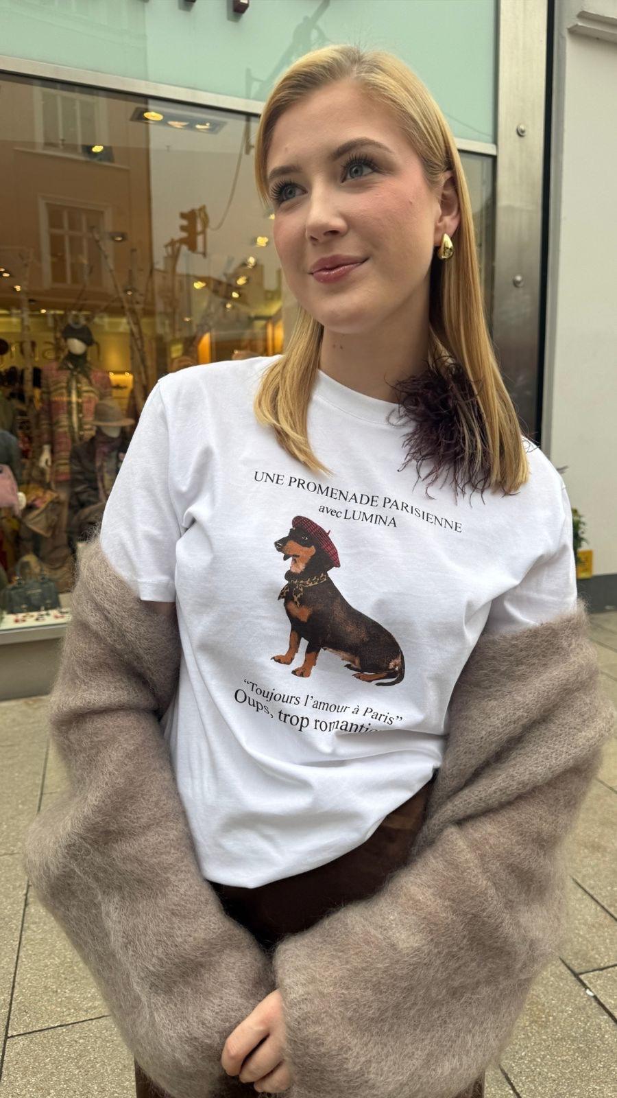 Junge Frau mit T-Shirt mit Dackelmotiv gestylt mit Jacke und Federbrosche vom Hamburger Modelabel stegmann mode