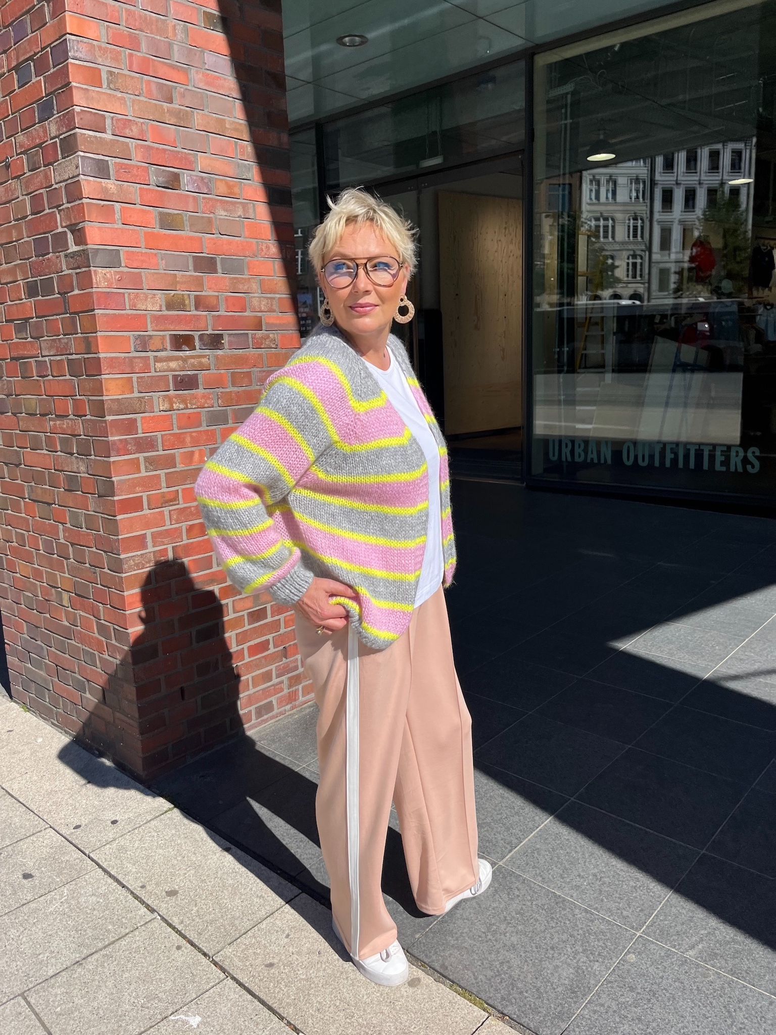 Verena trägt die gestreifte Strickjacke Marcella in den Farben Grau/Rosa/Gelb vom Hamburger Modelabel stegmann mode