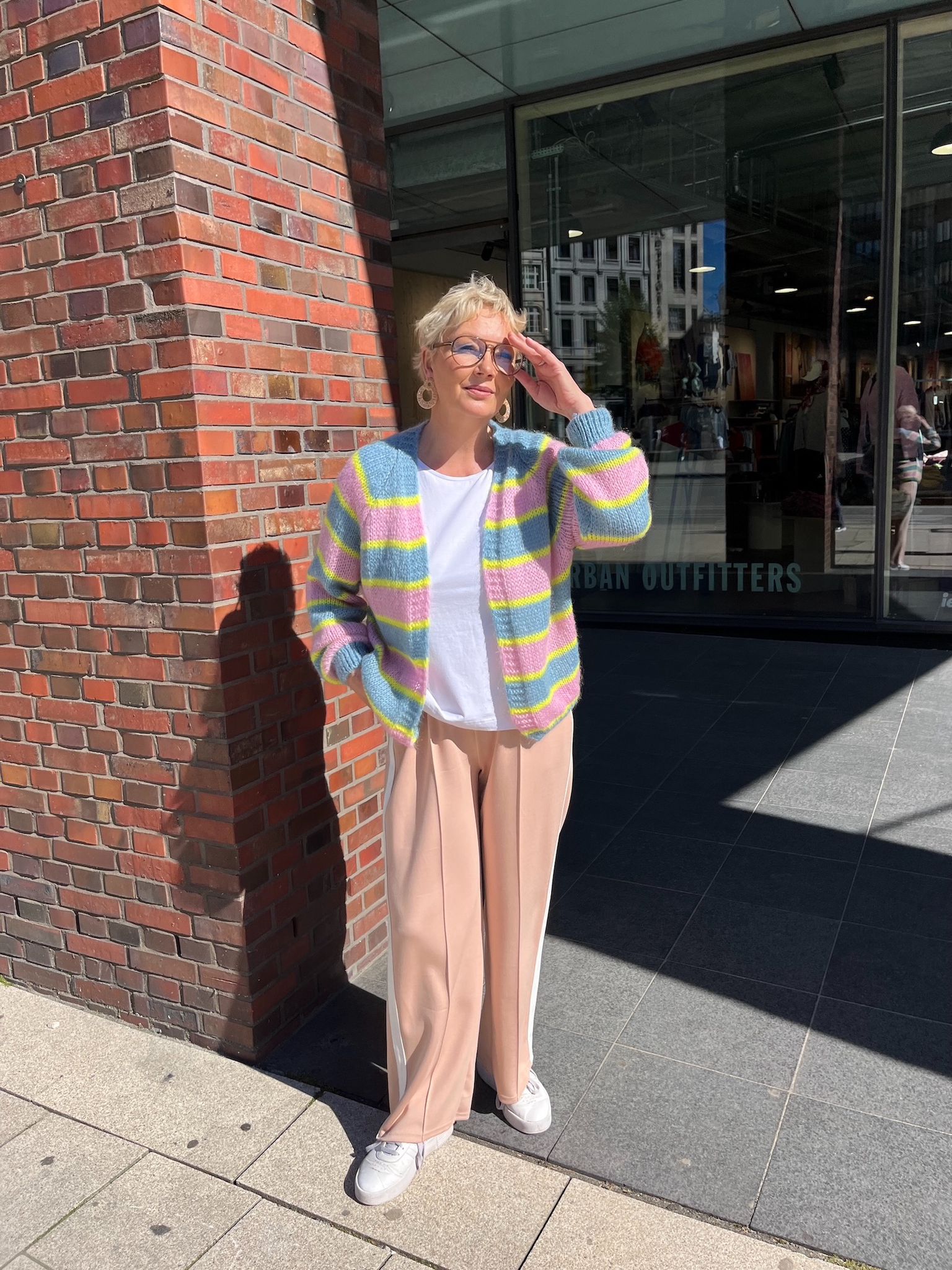 Verena trägt die gestreifte Strickjacke Marcella in den Farben Jeansblau/Rosa/Gelb vom Hamburger Modelabel stegmann mode